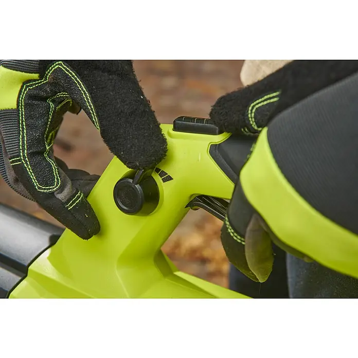 Ryobi ONE+HP Akku-Laubbläser RY18BLXD-0 Whisper - Ohne Akku, Blasgeschwindigkeit: 200 km/h, Blasleistung: 12,75 m³/min - Ein Laubbläser in hellgrüner Farbe wird von zwei Händen mit schwarzen Gartenhandschuhen gehalten, die Einstellungen regulieren.