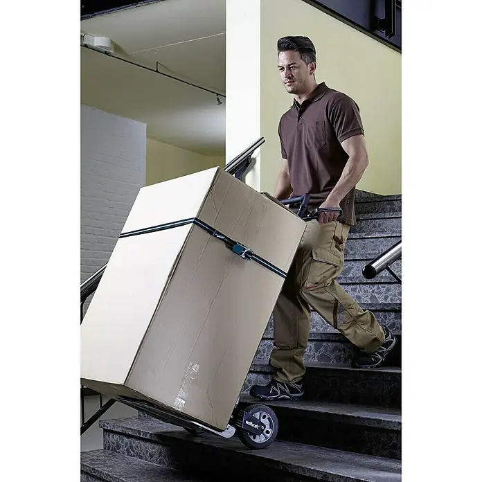 Wolfcraft Carretilla de mano TS 1500 - Capacidad de carga: 200 kg - El hombre transporta una caja grande con el carro de mano Wolfcraft para subir escaleras. El carro facilita el transporte de cargas pesadas.