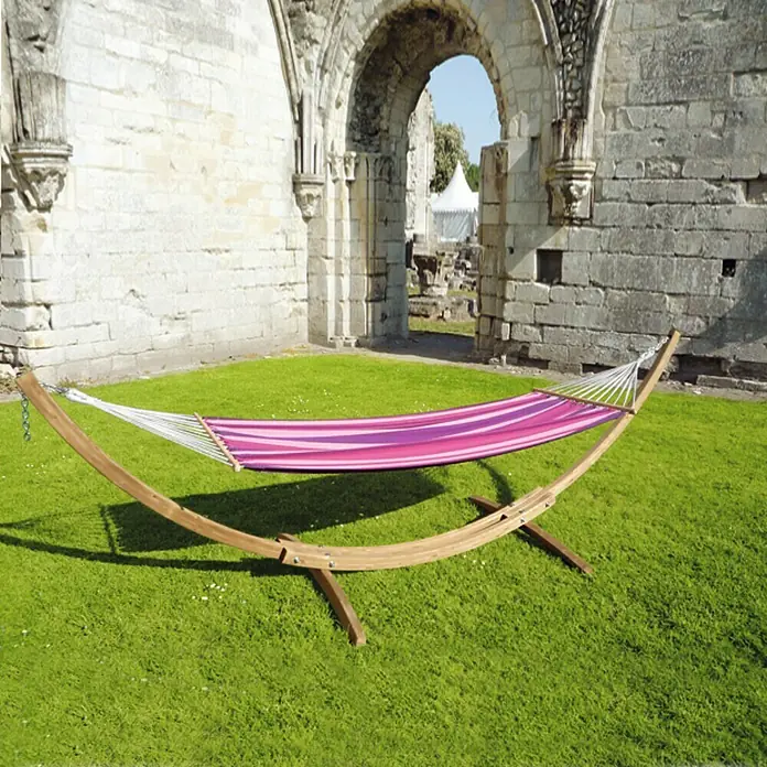 Amazonas Hängematten-Set StarSet Candy - 358 x 113 x 105 cm, Rosa/Violett - Einladende Hängematte mit Holzgestell und farbenfrohen Streifen vor einer historischen Steinruine. Ideal zum Entspannen im Freien.
