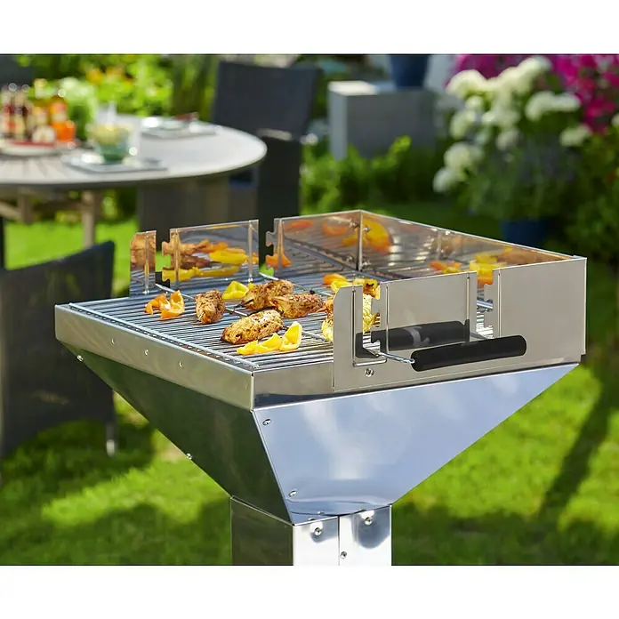 Grillstar Holzkohlegrill Colorado - Grillfläche (B x T): 48 x 46 cm, Silber - Grill mit Fleisch und Gemüse. Der Grill ist aus Edelstahl und steht auf einer Wiese im Garten. Im Hintergrund sind Blumen und ein Tisch zu sehen.