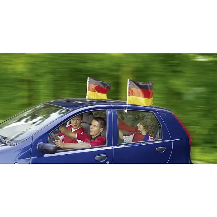 UniTEC Autoflaggen - Schwarz/Rot/Gold, 2 Stk. - Ein blaues Auto fährt mit drei Fußballfans und Deutschlandflaggen auf dem Dach durch eine grüne Allee. Fußballfieber ist angesagt!