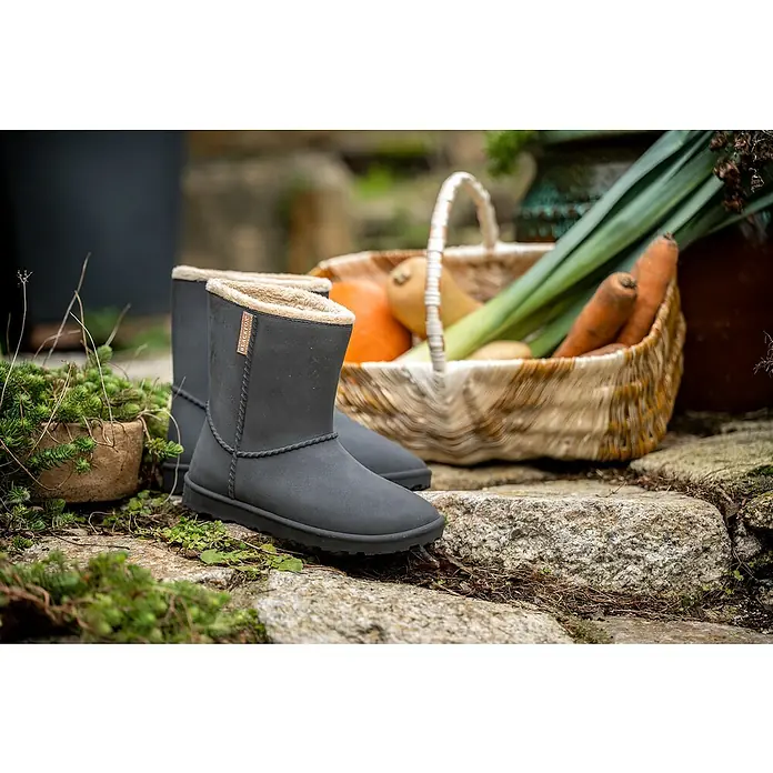 Black Fox Winterstiefel Cheyennetoo - Schuhgröße: 41, Schwarz - Graue Winterstiefel mit kuscheligem Innenfutter stehen neben einem Korb mit Gemüse. Ideal für kalte Tage und Gartenarbeit.