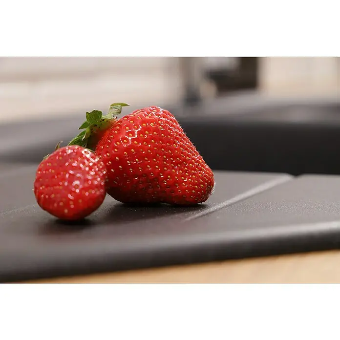 Respekta Einbauspüle Arlington - 110,5 x 52 cm, Schwarz - Zwei saftige Erdbeeren liegen auf einer modernen Küchenarbeitsplatte, perfekt für einen gesunden Snack oder ein leckeres Dessert.