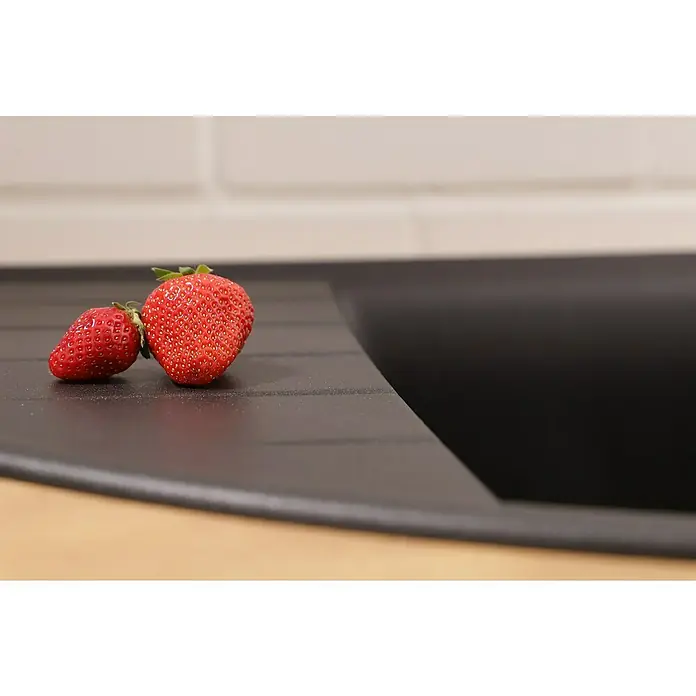 Respekta Einbauspüle Arlington - 110,5 x 52 cm, Schwarz - Zwei saftige Erdbeeren liegen auf einer dunklen Küchenarbeitsplatte, bereit für den Genuss. Die roten Früchte heben sich farblich ab.