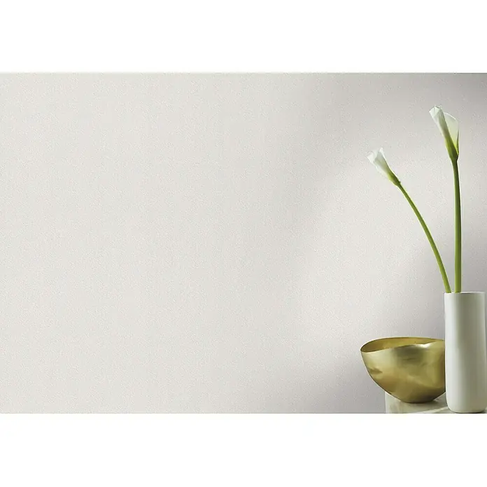 Rasch Vliestapete Geflechtstruktur - Weiß, Uni, 10,05 x 0,53 m - Stillleben mit einer weißen Vase, zwei Calla-Lilien und einer goldenen Schale auf einem Tisch vor einer weißen Wand.