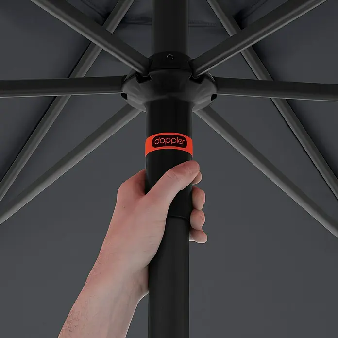 Doppler Marktschirm rund myZone Push Up - Anthrazit, Durchmesser Bespannung: 300 cm - Nahaufnahme eines Doppler-Sonnenschirms, der von einer Hand gehalten wird, mit Fokus auf das Markenlogo.