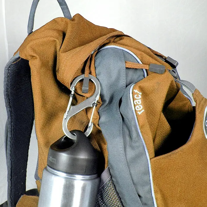 Nite Ize Doppelkarabiner Slide Lock - 89 x 38 mm, Edelstahl, Silber, Belastbarkeit: 33 kg - Nahaufnahme eines Rucksacks mit befestigter Wasserflasche, gehalten von einem Karabiner. Praktisches Design für unterwegs.