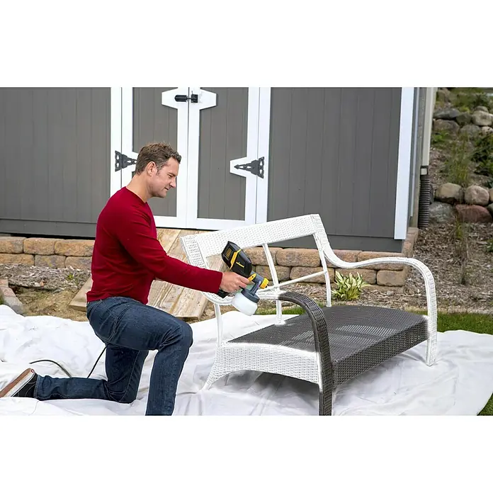 Wagner Farbsprühsystem W 150 Wood & Metal - 300 W, Förderleistung: 0,14 l/min - Mann lackiert eine Gartenbank mit einer Wagner Farbspritzpistole, um ihr ein frisches Aussehen zu verleihen. Perfekt für DIY-Projekte!