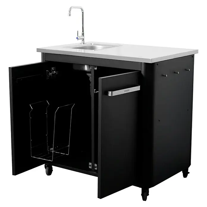 Cozze Outdoorküchen-Modul Spüle - Schwarz, B x T x H: 93,5 x 67 x 90 cm - Das Bild zeigt einen schwarzen Cozze Outdoor-Küchenschrank mit Spüle und weißer Arbeitsplatte, dessen Türen geöffnet sind.