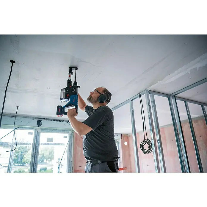 Bosch Professional AMPShare 18V Akku-Bohrhammer GBH 18V-28 D - 18 V, Ohne Akku - Ein Mann bohrt mit einer Bosch Akku-Bohrmaschine mit Staubabsaugung ein Loch in die Decke. Ideal für staubfreies Arbeiten!
