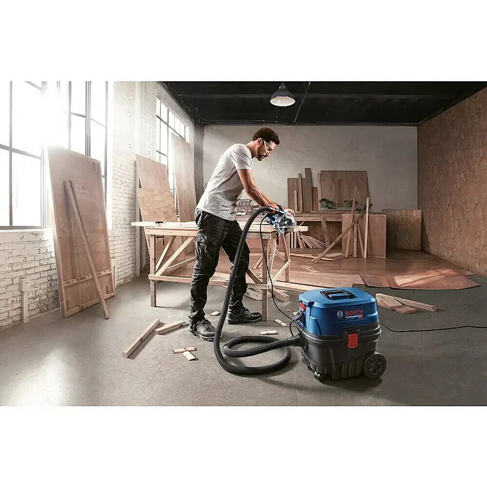 Bosch Professional Elektro-Nass- & Trockensauger GAS 12-25 PL - 1.250 W, Behältervolumen: 25 l, Mit Beutel - Ein Bosch Nass- und Trockensauger wird in einer Werkstatt verwendet, um Staub und Späne zu entfernen.