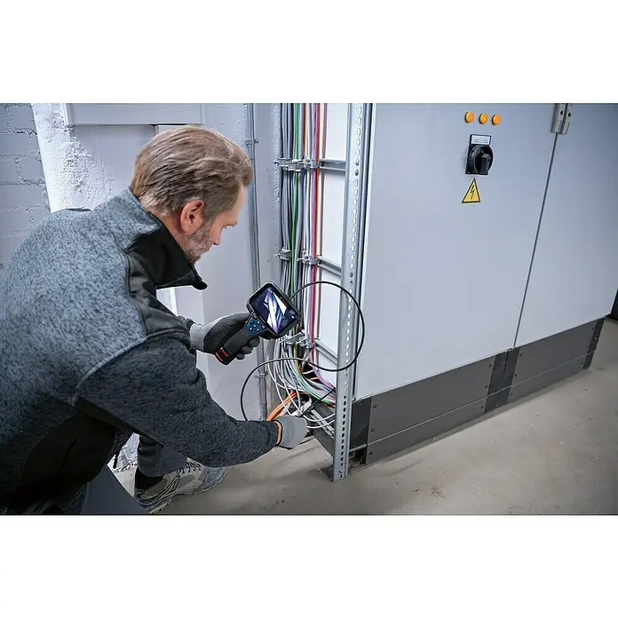 Bosch Professional Inspektionskamera GIC 12V-5-27 C - 12 V, Ohne Akku, Batteriebetrieben - Ein Mann, der elektrische Leitungen mit einer Bosch Inspektionskamera prüft, wobei die Kamera in Fokus steht.
