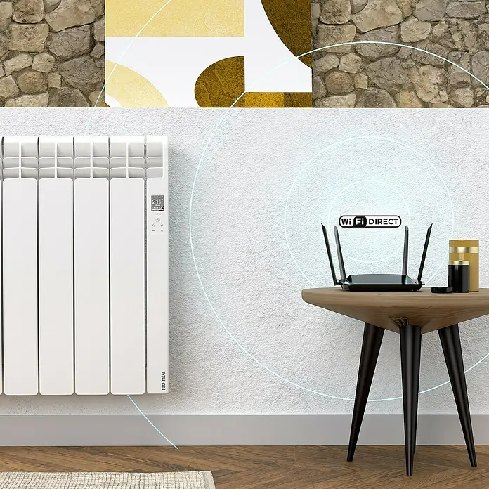 Rointe Emisor térmico Delta - 770 W, Blanco, 9,7 x 67,5 x 58,5 cm, Fluido - La imagen muestra un router sobre una mesa con un indicador WiFi Direct, al lado de un radiador en la pared.