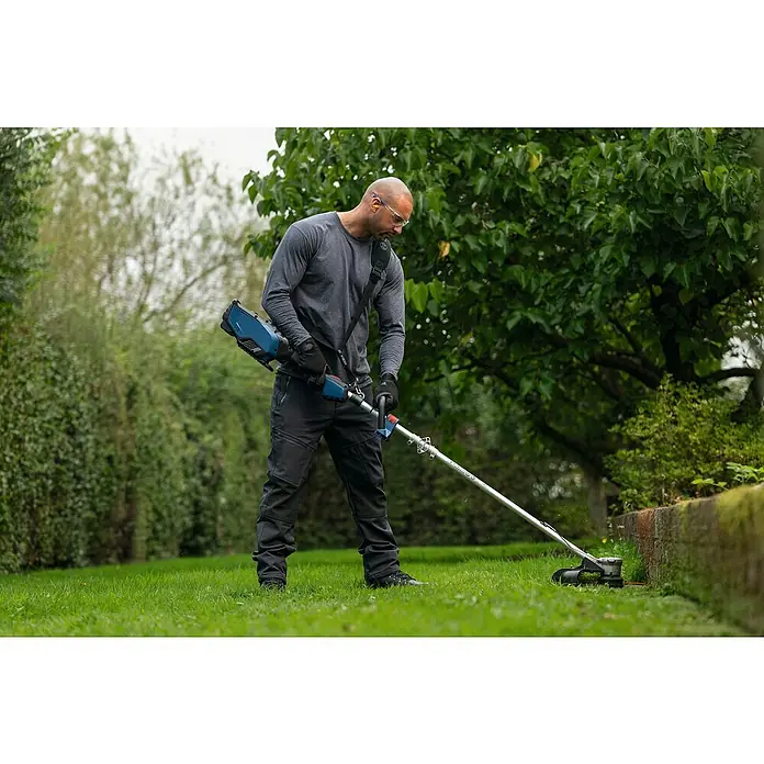 Bosch Universal Elektro-Rasenmäher UniversalRotak 34-405 - 1.300 W, Schnittbreite: 340 mm - Mann mit Rasentrimmer bei der Arbeit. Der Akku-Rasentrimmer sorgt für einen präzisen Schnitt und erleichtert die Gartenarbeit.