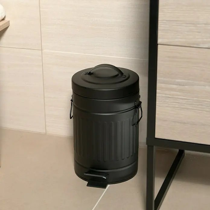 Venus Treteimer Tonne - 3 l, Metall, Schwarz - Schwarzer Treteimer aus Metall mit Deckel und Griff, steht neben einem Waschbecken auf einem beigen Fliesenboden.