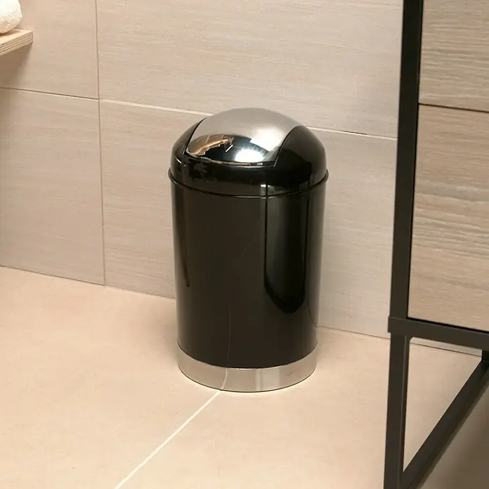 Venus Milano Badeimer - 5 l, Kunststoff, Schwarz - Eine Nahaufnahme eines schwarzen Mülleimers mit silbernem Deckel in einem Badezimmer. Der Mülleimer steht auf beigem Fliesenboden.