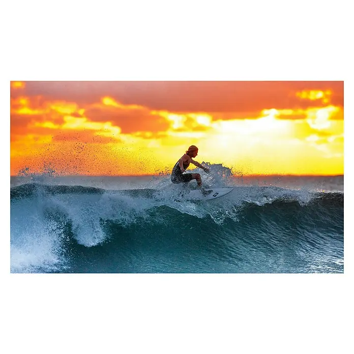 Paddle Leash XQMax - Ajustable: 30 cm - 245 cm - Un surfista cabalga una ola durante la puesta de sol, capturando el dinamismo del deporte y la belleza de la naturaleza. Un momento inolvidable.