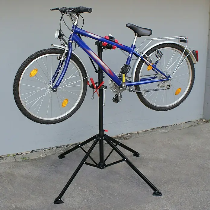 Eufab Fahrradmontageständer PROFI - Geeignet für: Rahmenstärke 2,5 - 4 cm, Nutzlast: 30 kg - Ein blaues Fahrrad, das auf einem schwarzen Fahrradreparaturständer steht, perfekt für Wartung und Reparaturen zu Hause.