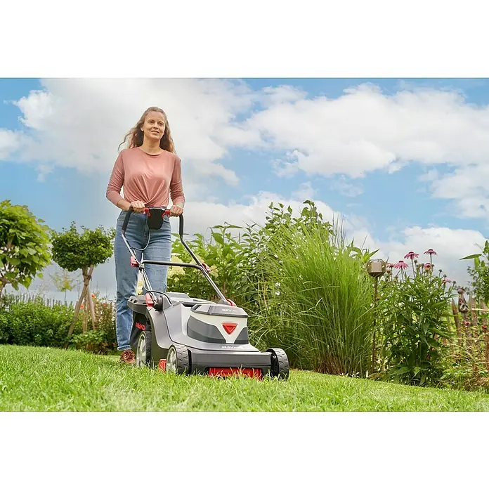 AL-KO Comfort Akku-Rasenmäher 38.5 Li - 36 V, 1 Akku, 4 Ah, Schnittbreite: 38 cm - Frau mäht Rasen mit AL-KO Akku-Rasenmäher. Das Gerät bietet kabellose Freiheit und präzise Schnittergebnisse für einen schönen Garten.