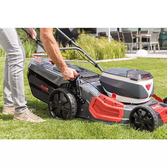 AL-KO Premium Akku-Rasenmäher 512 Li VS-W - 36 V, 2 Akkus, 4 Ah, Schnittbreite: 51 cm - Eine Person bedient einen dunkelgrau-roten AL-KO Rasenmäher.