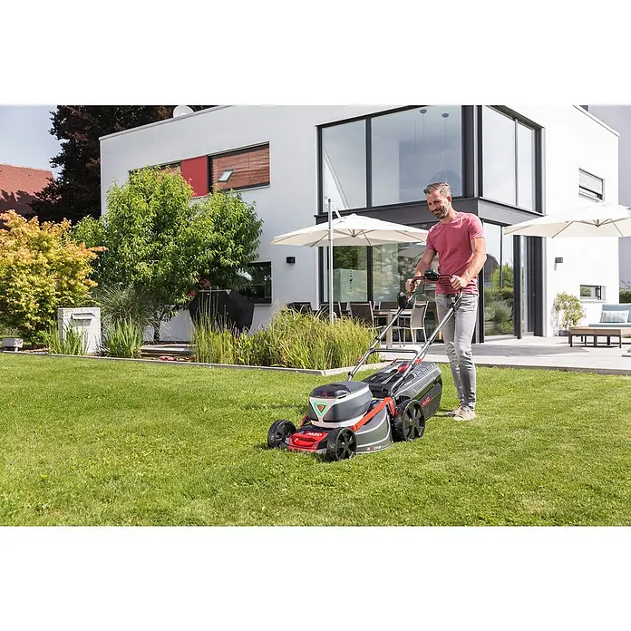 AL-KO Premium Akku-Rasenmäher 512 Li VS-W - 36 V, 2 Akkus, 4 Ah, Schnittbreite: 51 cm - Ein Mann mäht den Rasen mit einem AL-KO Rasenmäher vor einem modernen Haus.