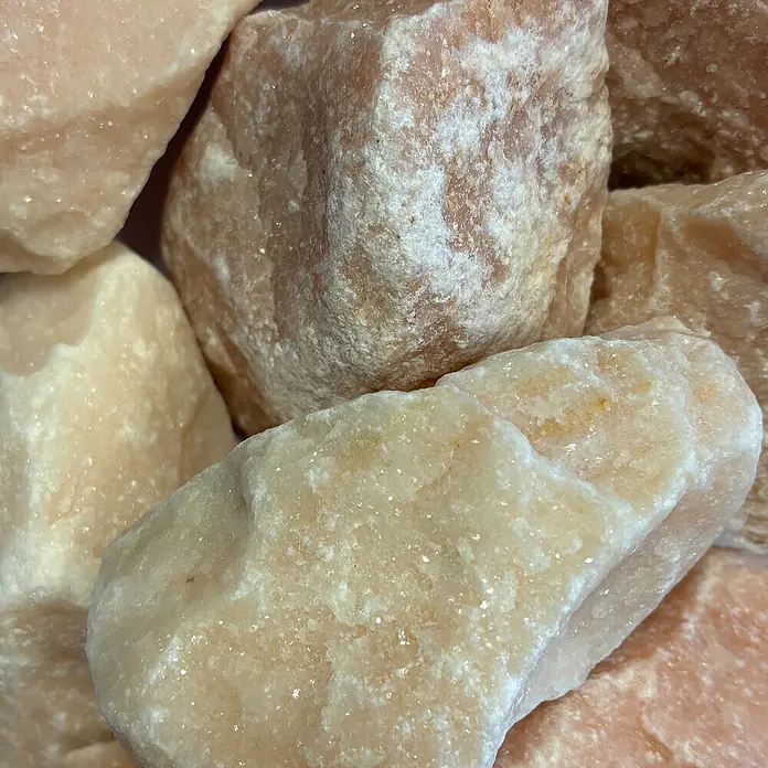 Hamann Mercatus Marmorsplitt - Rosairio, Körnung: 30 mm - 60 mm, 25 kg - Nahaufnahme von einer Ansammlung zartrosa Rosenquarzstücke, die die Textur und die sanfte Farbpalette des Minerals hervorhebt.