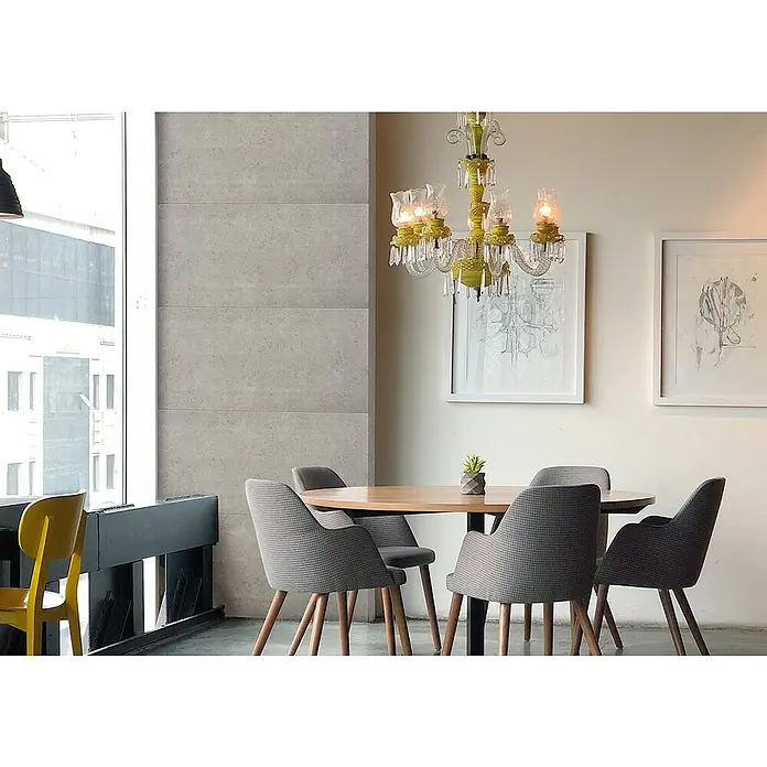 Nmc Decoflair Wandpaneel - Beton Light, 100 x 50 cm, Kunststoff - Ein einladender Essbereich mit einem runden Holztisch, umgeben von grauen Stühlen, unter einem dekorativen Kronleuchter.