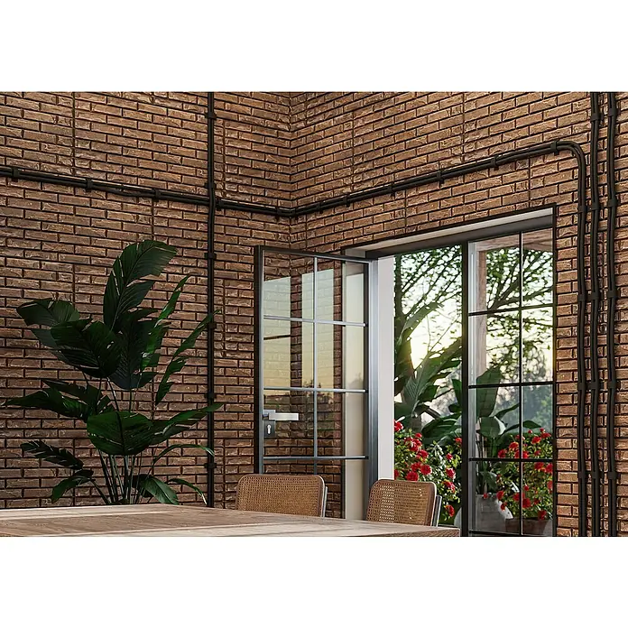Nmc Decoflair Wandpaneel - Stone Wall Iron, 100 x 50 cm, Kunststoff - Das Bild zeigt eine Inneneinrichtung mit einer Backsteinwand, durch die ein Fenster den Blick auf einen üppigen Garten freigibt.