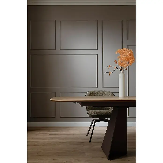 SCHÖNER WOHNEN-Kollektion Zierprofil Wandleiste Elegant 4 - 200 cm x 11 mm x 22 mm, Hochverdichtetes extrudiertes Polymer (HDPS) - Elegantes Interieur mit einem modernen Esstisch mit braunem Untergestell und einem weißen Vase mit Blumen.