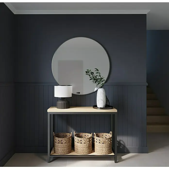 Nmc Decoflair Zierprofil Deckenleiste D13 - 6 Stk., 200 cm x 42 mm x 49 mm, Extrudiertes Polystyrol (XPS) - Elegante Konsolentisch-Szene mit rundem Spiegel, Lampe, dekorativer Vase und drei Körben auf einem Regal, die ein stilvolles Interieur-Arrangement bilden.