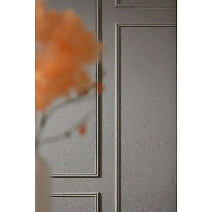 SCHÖNER WOHNEN-Kollektion Rahmen-Set Elegant 4 - Hochverdichtetes extrudiertes Polymer (HDPS) - Nahaufnahme einer Wand mit Zierleisten und einem unscharfen orangefarbenen Objekt im Vordergrund, das einen modernen Akzent setzt.