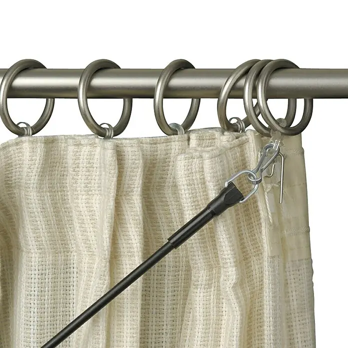 Varilla para cortinas - L x An x Al: 103 x 0,5 x 0,5 cm, Transparente - Primer plano de una barra de cortina con anillas y una cortina beige sujeta a las anillas.