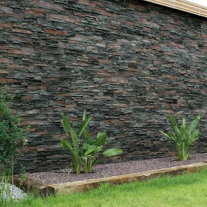 Revestimiento de piedra Petra Onix - Cantidad total: 4 pzs., Onix - Revestimiento de fachada de piedra con plantas en el jardín, creando un ambiente natural y elegante.