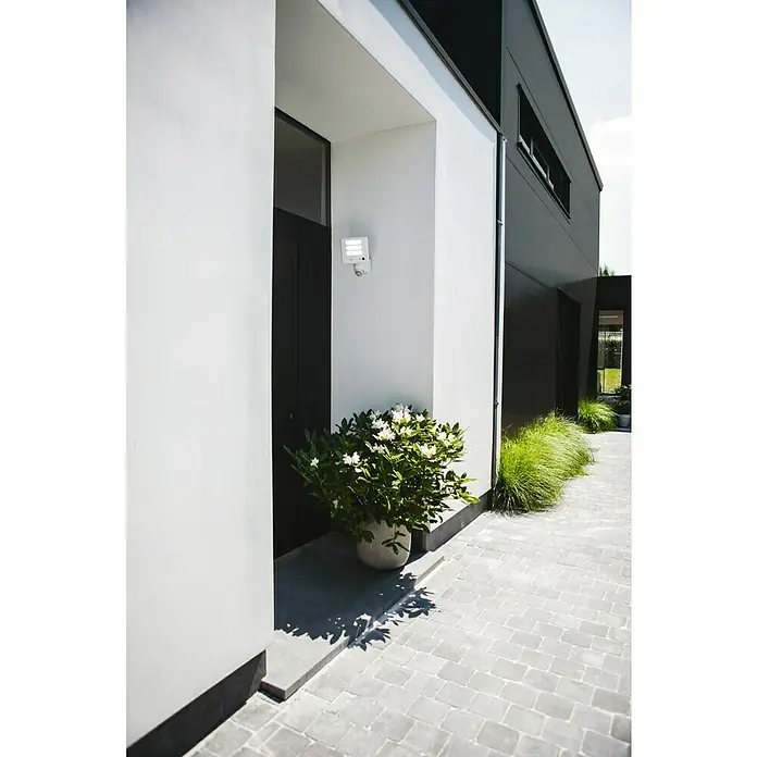 Lutec Proyector LED Esa con sensor y cámara - 25 W, L x An x Al: 19,3 x 20 x 26,8 cm, Blanco, Blanco frío - Moderna toma exterior de una casa elegante, centrándose en una elegante lámpara de exterior.