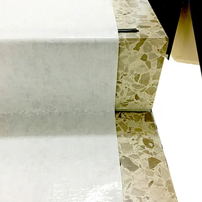 Universal-Vlies10 x 0,5 m - Nahaufnahme von zwei Treppenstufen mit hellen Oberflächen, die eine moderne und minimalistische Ästhetik aufweisen.