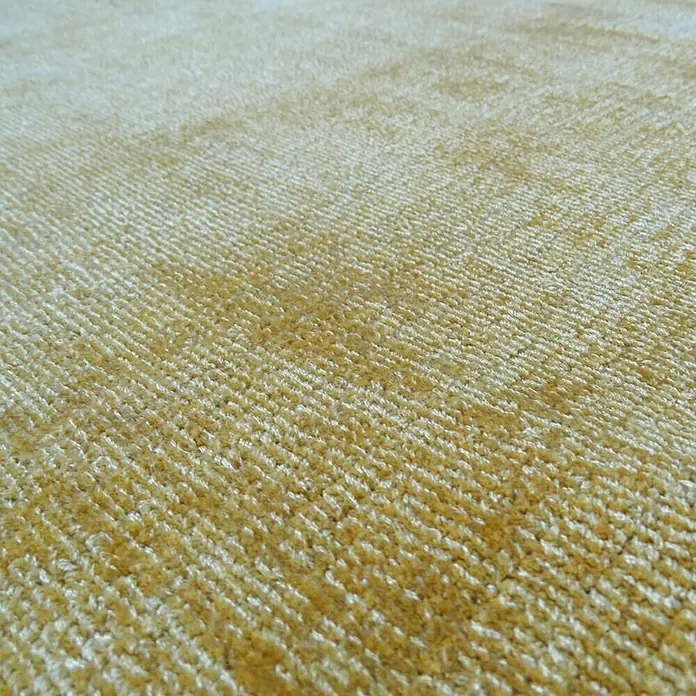 Kayoom Kurzflorteppich Luxury - Gelb, 170 x 120 cm, 100 % Viskose - Nahaufnahme eines gelben Teppichs mit feiner Textur, ideal für gemütliche Wohnräume und zur Schaffung einer warmen Atmosphäre.