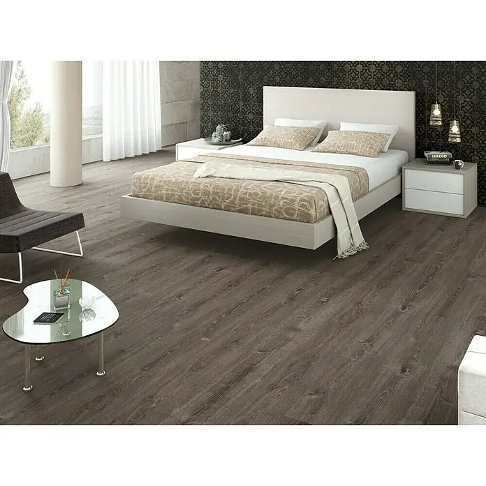 LOGOCLIC Laminado Roble Comarea - 1.200 x 196 x 8 mm, Roble Comarea, AC5 - Dormitorio con suelo laminado imitación madera, cama clara con mesita de noche y una mesa de centro moderna. Ambiente acogedor con diseño elegante.