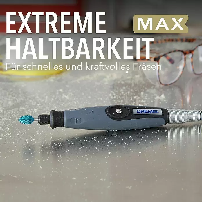 Dremel Raspelfräser MAX Power Carving 9953 - Flammenförmig - Graues Dremel-Multifunktionswerkzeug mit blauem Fräskopf auf staubiger Oberfläche, zeigt Haltbarkeit beim Fräsen.