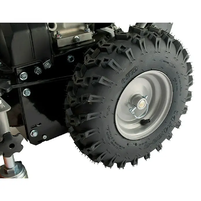 Stiga Kehrmaschine SWS 600 G - 4,4 kW, Arbeitsbreite: 60 cm - Nahaufnahme eines robusten, profilierten Reifens an einer schwarzen Maschine, ideal für unebenes Gelände.