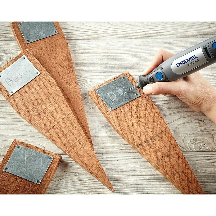 Dremel Diamant-Schleifstifte Mod. 7103 - Durchmesser Kopf: 2 mm, 2 Stk. - Eine Nahaufnahme von Pflanzschildern aus Holz mit gravierten Metallschildern, die mit einem Dremel-Werkzeug beschriftet werden.