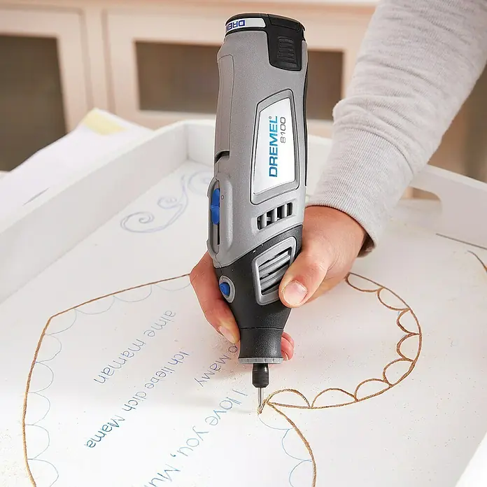 Dremel Graviermesser 105 - Arbeitsdurchmesser: 0,8 mm, 3 Stk. - Nahaufnahme eines Dremel 8100 Multifunktionswerkzeugs beim Gravieren einer Holzoberfläche, ideal für DIY-Projekte und feine Detailarbeiten.