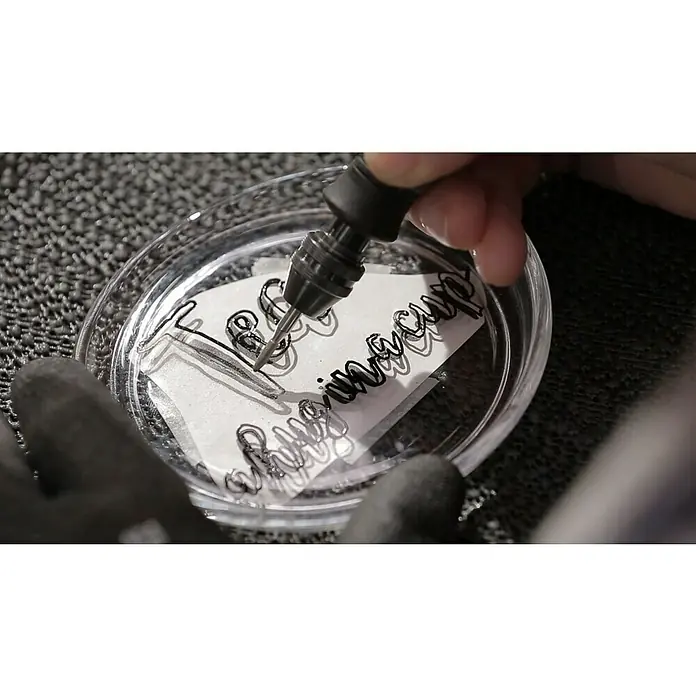 Dremel Diamant-Schleifstifte Mod. 7144 - Durchmesser Kopf: 2,4 mm, 2 Stk. - Nahaufnahme eines Werkzeugs, das präzise Gravuren auf einer Oberfläche vornimmt, ideal für detaillierte Handwerksarbeiten und künstlerische Projekte.