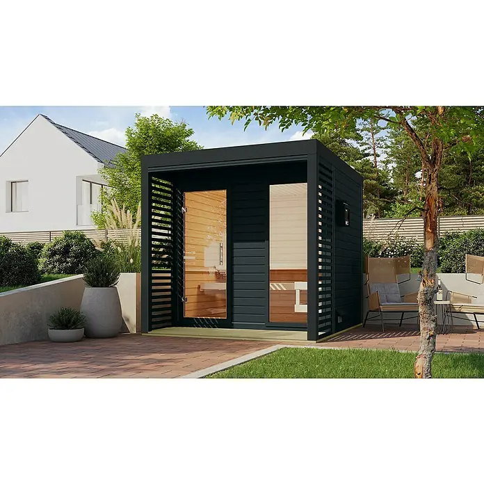 Karibu Saunahaus Ares - Elektroofen, Steuerung Ofen: Extern, L x B x H: 276 x 231 x 231,5 cm - Außenansicht einer modernen Sauna mit Holzverkleidung und Glasfront, umgeben von Grün. Entspannungsbereich mit Stühlen im Außenbereich.