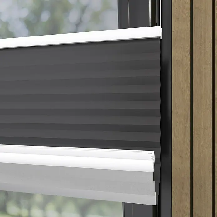 Plissee Basic VS Thermo - B x H: 75 x 130 cm, Anthrazit, Verdunkelnd - Nahaufnahme von grauen, gefalteten Fensterabdeckungen mit weißen Akzenten, die eine moderne und elegante Fensterdekoration zeigen.