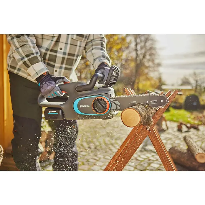 Gardena Power for All 18V Akku-Kettensäge PowerSaw 250/18V - 18 V, Ohne Akku, Schwertlänge: 25 cm - Nahaufnahme einer Gardena Akku-Kettensäge im Einsatz, die Holz auf einem Sägebock zersägt.
