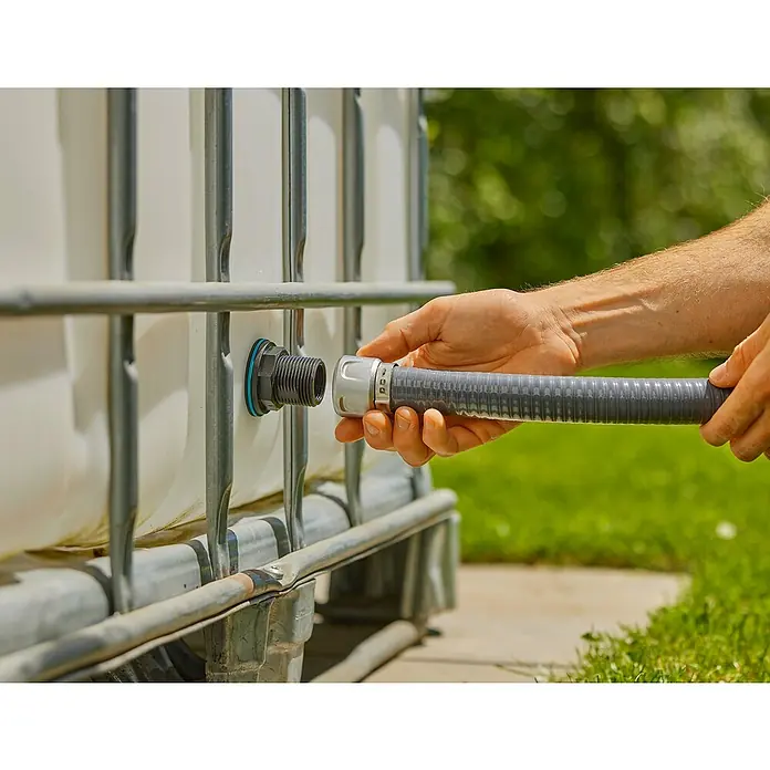 Gardena Anschlussstück Push In G1"-G3/4" - Passend für: Wassertanks mit 2-10 mm Wandstärke & Radius von min. 50 cm - Anschluss eines grauen Schlauches an einen IBC-Wassertank mit blauen Dichtungen und grauen Metallstäben.