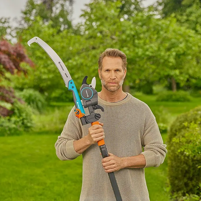 Gardena StarCut Baumsäge Pro L Set - Max. Aststärke: 32 mm, Längenverstellung: 175 cm - 400 cm - Mann hält eine GARDENA Hochentaster TCS 720/20, ein Werkzeug zum Schneiden hoher Äste. Ideal für Baumpflegearbeiten im Garten.