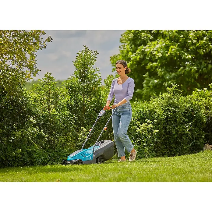 Gardena Power for All 18V Akku-Rasenmäher EasyMax 32/18V - 18 V, Ohne Akku, Schnittbreite: 32 mm - Eine Frau benutzt einen Rasenmäher im Garten, um das Gras zu schneiden. Der Rasenmäher ist blau und grau.