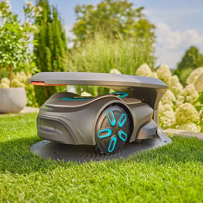 Gardena Mähroboter-GarageGardena Mähroboter smart SILENO pro / max / free - Ein Gardena Mähroboter steht auf einem grünen Rasen, bereit für die Gartenarbeit. Das moderne Design und die praktischen Funktionen erleichtern das Rasenmähen.