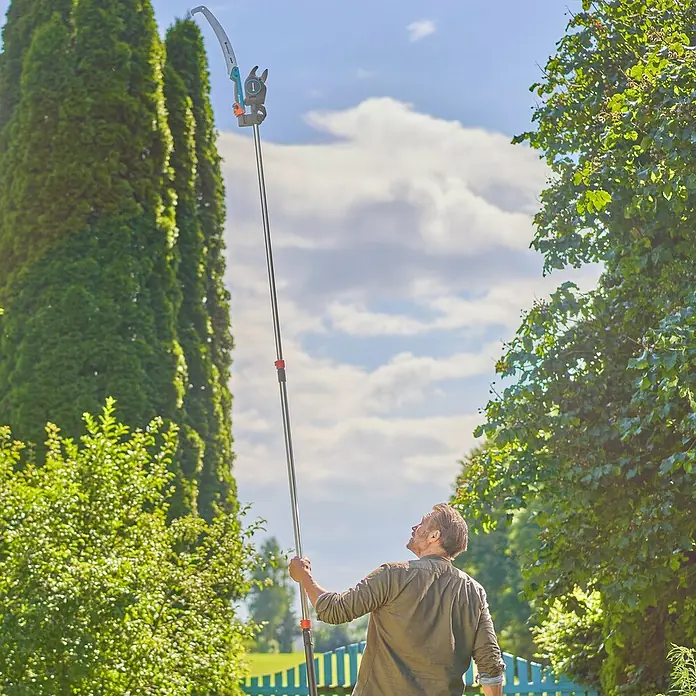 Gardena StarCut Astsäge - Länge: 59,4 cm, Passend für: GARDENA Baum- und Strauchschneider StarCut Pro L - Der Mann benutzt eine Gardena Hochentaster, um die hohen Äste zu erreichen. Das Werkzeug ermöglicht es, sicher vom Boden aus zu schneiden.